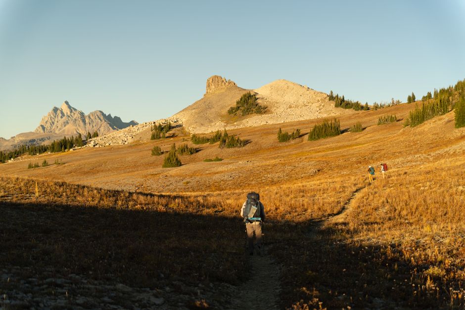 Backpackers hiking the dramatic Teton Crest Trail during autumn in Wyoming, USA.